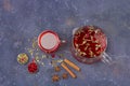 Red tea rooibos, hibiscus, karkade in glass cup and teapot among cinnamon, anise, cranberries on a dark background. Herbal, Royalty Free Stock Photo