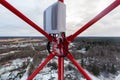 Red telecommunication tower or mast and remote electric tilt and remote radio unit with power and optic cables in winter day Royalty Free Stock Photo