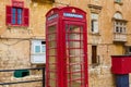 A red telephone booth on the background of an old residential building Royalty Free Stock Photo
