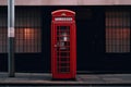 A red telephone booth is on the sidewalk in front of a building. Royalty Free Stock Photo