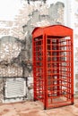 Red telephone box front brick wall block. Royalty Free Stock Photo