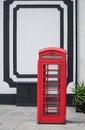 Red Telephone Box in front of a white wall in London at daylight. Royalty Free Stock Photo