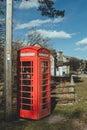 Red telephone box on a side of a road in the countryside in the UK Royalty Free Stock Photo