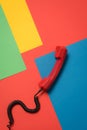 Red telephone handset with curly cord on bright background Royalty Free Stock Photo