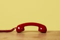 Red telephone off the hook on a yellow background