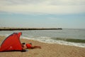 Red tent on a summer day with a man sleeping on the Black Sea Coast