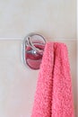 Red terry towel hangs from a chrome wall hook Royalty Free Stock Photo