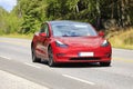 Red Tesla Model 3 Electric Car on Road Royalty Free Stock Photo