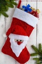 Red textile boot a Christmas with Santa`s head, with gifts and green of spruce branches Royalty Free Stock Photo