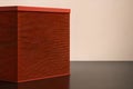 Red textured plinth or box on a brown base against a warm brown background. Generative AI