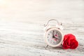 Red textured roses and alarm clock close-up and copy space. Women`s day, mother`s day, red roses and a clock on a white wooden bac Royalty Free Stock Photo