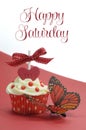 Red theme cupcake with butterfly on red and white background with Happy Saturday sample text Royalty Free Stock Photo