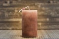 Red thick candle on a wooden table