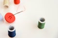 Multi colored thread spools, needle and red button Royalty Free Stock Photo