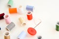 Multi colored thread spools, needle and red button Royalty Free Stock Photo