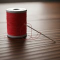 Red thread spool and needle on wooden surface Royalty Free Stock Photo