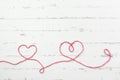 Red thread and two hearts on light background Royalty Free Stock Photo