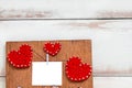 Red three hearts and a small white card on a brown wooden panel