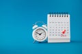 Red thumbtack pin on the last day of month with circle and pay day word near white analog clock on grunge blue background Royalty Free Stock Photo