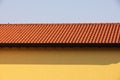 Red tile roof on the yellow wall of a house in the village. Royalty Free Stock Photo