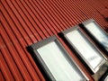 Red tiled house roof with attic windows. Roofing construction, window installation, modern architecture concept Royalty Free Stock Photo