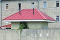 red tiled metal roof on a small private house behind a gray concrete fence Royalty Free Stock Photo
