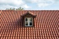 Red tiled roof with attic. Dormer window white color on garret, rooftop Royalty Free Stock Photo