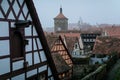 Red tiled roofs, stone gothic towers, fog, renaissance and gothic historical buildings, old town, medieval street, half-timbered