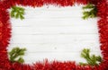 A red tinsel frame on a white background with Christmas tree branches in the corners Royalty Free Stock Photo