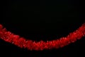Red tinsel, glitter, trumpery on black color background