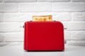 Red toaster with toasted bread for breakfast inside. Royalty Free Stock Photo