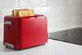 Red toaster with toasted bread for breakfast inside. Royalty Free Stock Photo