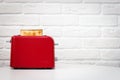 Red toaster with toasted bread for breakfast inside. Royalty Free Stock Photo