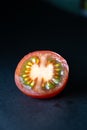 The red tomato cut half-and-half on a black background Royalty Free Stock Photo