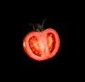 The red tomato cut half-and-half on a black background. Royalty Free Stock Photo