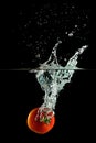 Red tomato falling into water splash on a black background Royalty Free Stock Photo