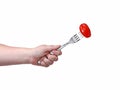 Red tomato on a fork in a female hand isolated on white background Royalty Free Stock Photo