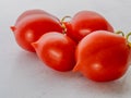 Red tomato grapes with points on stem against white, italian variety Piennello, Vesuvio Royalty Free Stock Photo