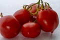 Red tomato grapes with points on stem against white Royalty Free Stock Photo