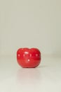 Red tomato-shaped kitchen timer with cooking in the background.