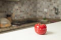 Red tomato-shaped kitchen timer with cooking in the background. Royalty Free Stock Photo