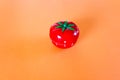 red tomato-shaped timer on orange background. Home related, home staying. Free copy space