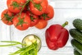 Red tomatoes on a branch, red bell peppers, large cucumbers, green onions in a glass Royalty Free Stock Photo