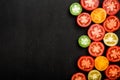 Red tomatoes of different colors cut in half. Juicy vegetables on black background