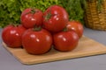 Red tomatoes with green salad, on brown wooden desk and gray background Royalty Free Stock Photo