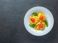 Red tomatoes and italian pasta with bazil leaves in plate with free space