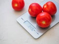 Red tomatoes on kitchen scale on white background. Product weigh Royalty Free Stock Photo