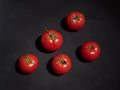 Red tomatoes with leaves on a black background. Shot over Royalty Free Stock Photo