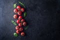 Red tomatoes sprinkled with salt on a dark concrete background. View from above. Fresh juicy tomatoes with salt and herbs Royalty Free Stock Photo