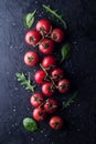 Red tomatoes sprinkled with salt on a dark concrete background. View from above. Fresh juicy tomatoes with salt and herbs Royalty Free Stock Photo